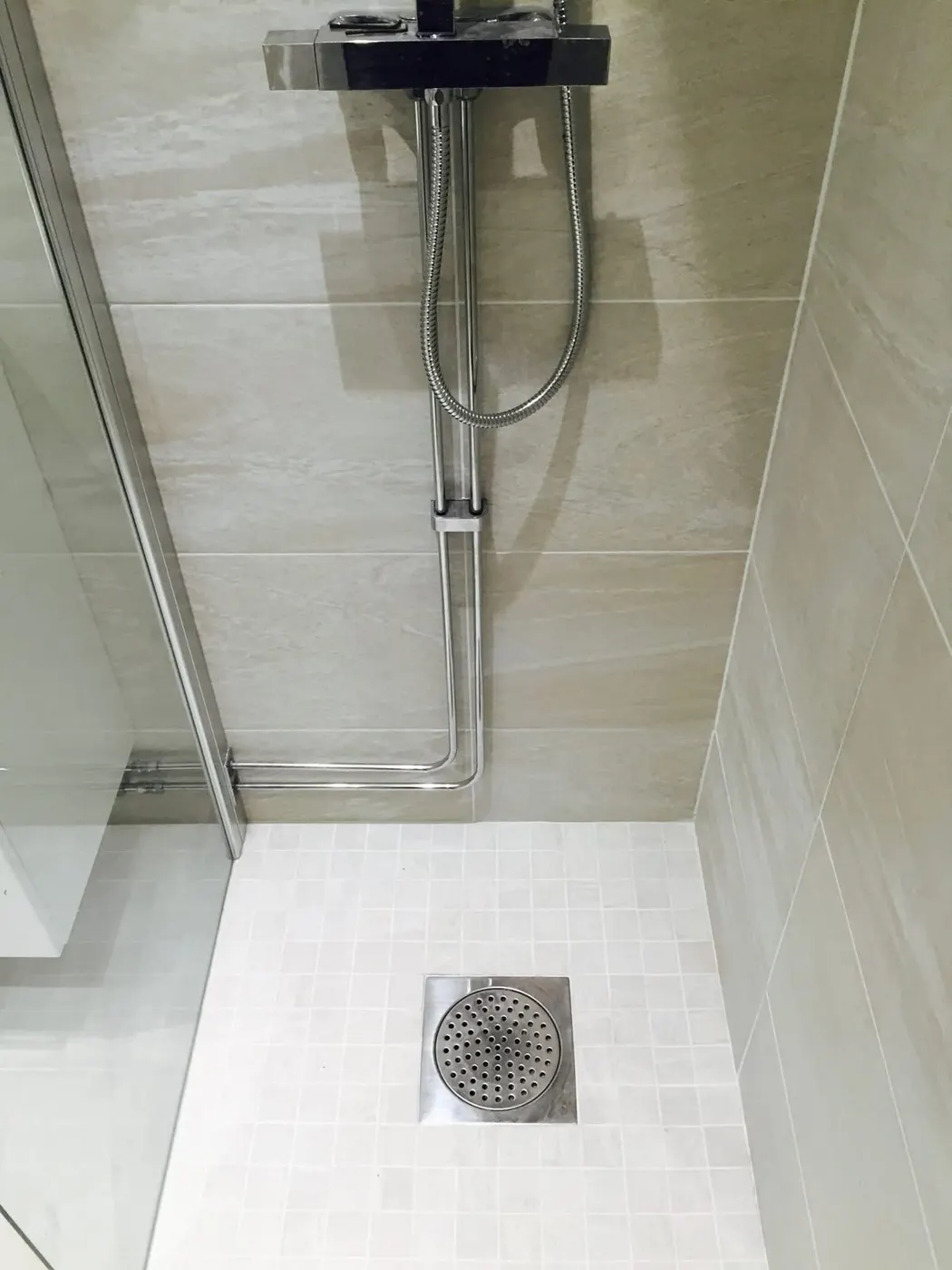 Douche en carrelage clair avec siphon