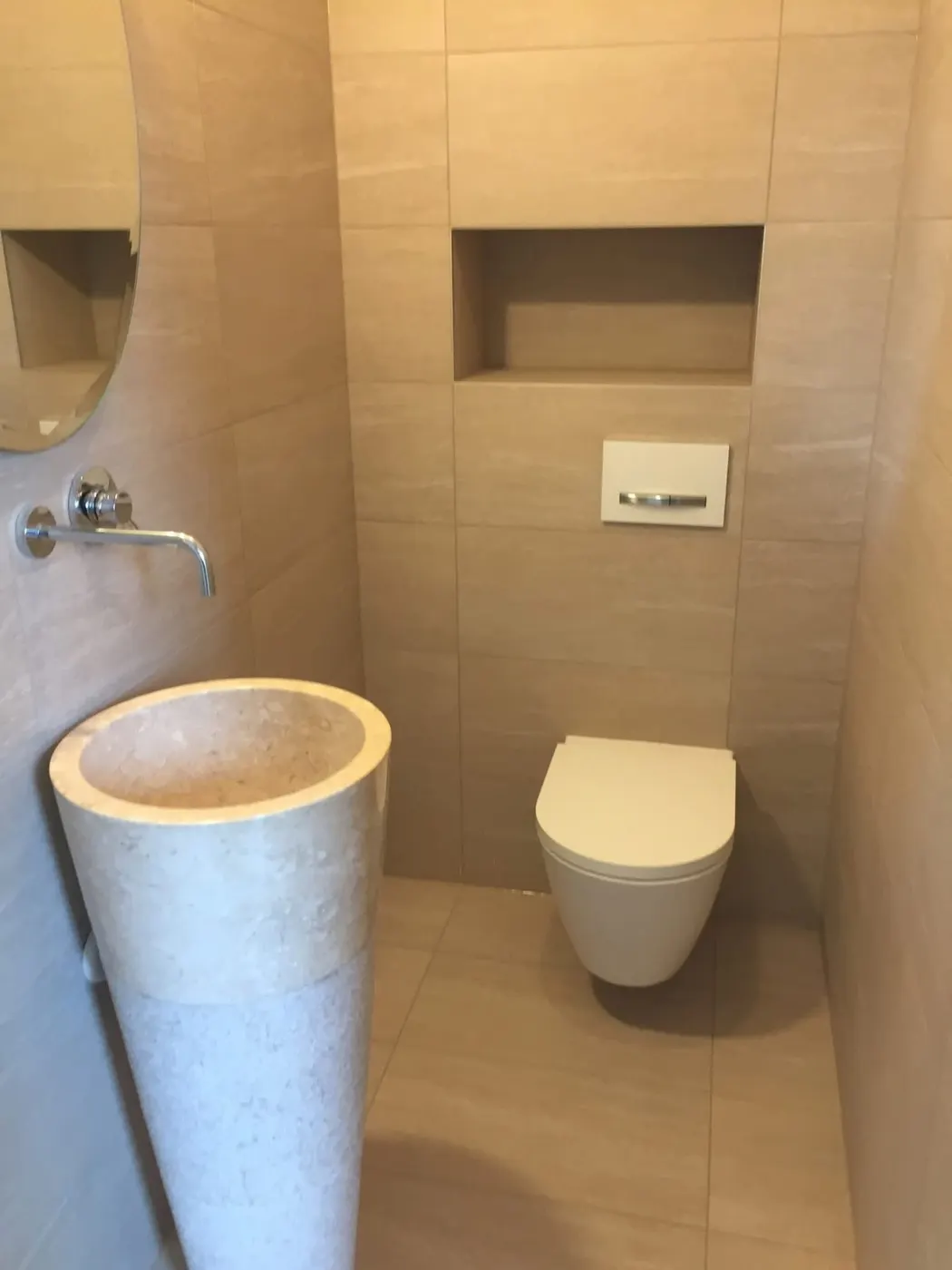 Toilettes en carrelage beige avec niche
